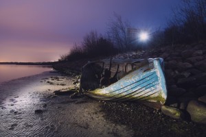 Old boat on Copenhagen shore at night 